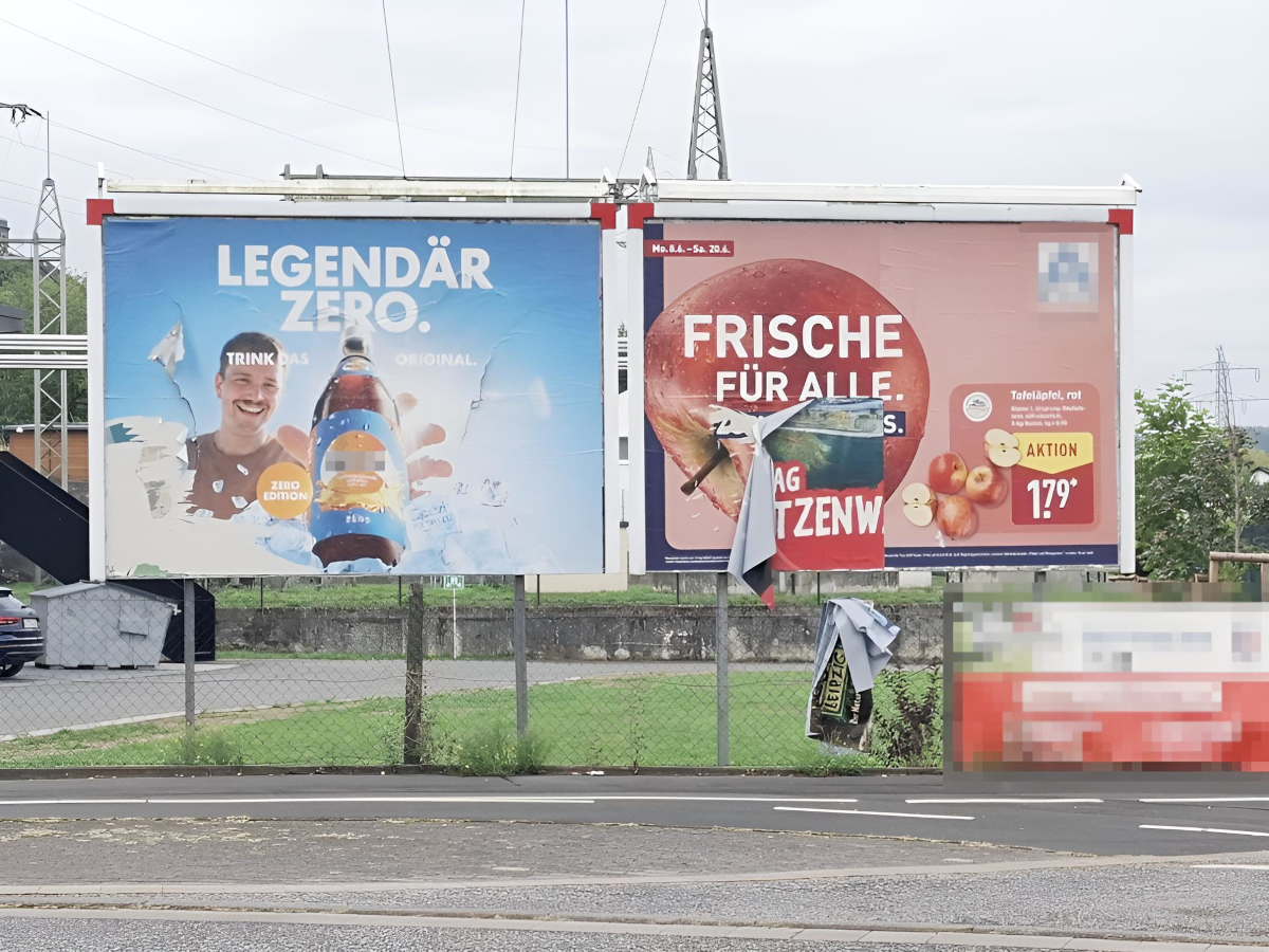 Beschädigte und abgelöste Plakatwerbung nach Regen an einer Werbetafel in Bad Hersfeld